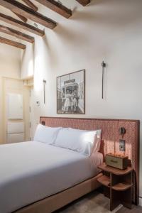 a bedroom with a white bed and a picture on the wall at POSTCODE Chueca in Madrid +62 photos