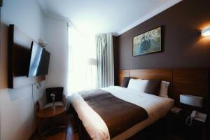 a hotel room with a bed and a flat screen tv at Elaf Almaqamah Nour Althuria Hotel in Mecca