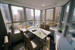 a dining room with a table and some windows at Elaf Almaqamah Nour Althuria Hotel in Mecca