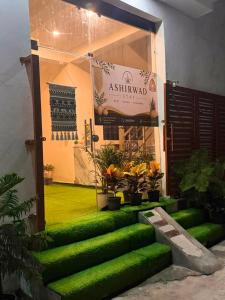 a building with a green front door with plants at Ashirwad Stay in Rishīkesh
