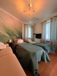 a bedroom with two beds and a chandelier at Casa Cri in Mondovì