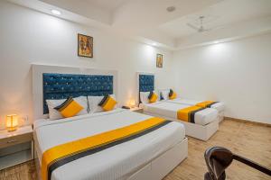 a bedroom with two beds and a desk with a chair at Itsy Hotels Riya Near IGI Airport in New Delhi +29 photos