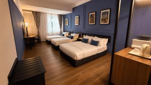 a hotel room with two beds and a desk at KL International Hotel in Kuala Lumpur