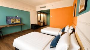 a hotel room with two beds and a flat screen tv at KL International Hotel in Kuala Lumpur
