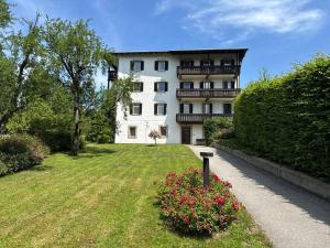 a large white building with a yard with flowers at Das Alpina in Bad Reichenhall
