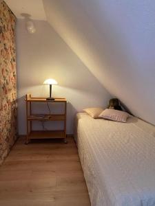 a bedroom with a bed and a table with a lamp at Apartment with a view in Upflamör in Zwiefalten
