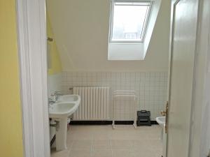 a bathroom with a sink and a radiator and a window at Appartements Tonton Jo in Camaret-sur-Mer +24 photos