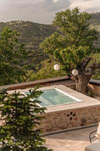 a jacuzzi tub with a view of the mountains at La Villa de Madeleine - Stone Villa with outdoor hot tub in Arcadia, Peloponnese in Áyios Ioánnis
