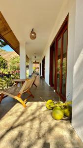 a porch of a house with chairs and a table at The Villa Indah Areguling in Kuta Lombok