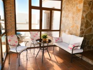 a patio with chairs and a table and a couch at Chalet Duna in El Palmar