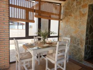 a dining room with a white table and chairs at Chalet Duna in El Palmar