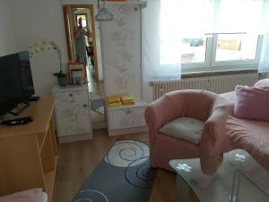 a living room with a chair and a television at Ferienwohnung Jahnke in Burkardroth