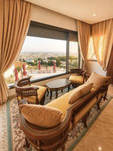 a living room with a couch and chairs and a large window at Chez Roberto in La Marsa
