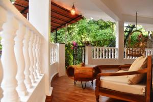 a living room with a couch and a balcony at Villa Pont Bleu in Canacona