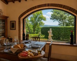 a dining room with a table and a large window at Borgo Livernano in Radda in Chianti