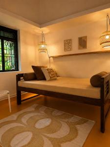 a bedroom with a bed with a lamp and a rug at Villa Pont Bleu in Canacona +22 photos