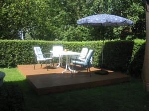 a patio with a table and chairs and an umbrella at Tor zum Darss in Pruchten
