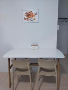 a white table and two chairs in a room at Good View Guest House in Phatthalung