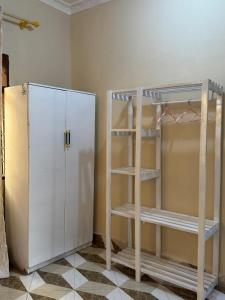 a room with a white refrigerator and a ladder at The Cozy Nest in Tanga