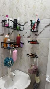 a bathroom with a sink and shelves on the wall at The Cozy Nest in Tanga