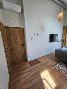 a bedroom with a bed and a wooden door at Winnica Tenczyn in Grojec