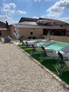 a group of picnic tables next to a swimming pool at L’alambic in Guizengeard
