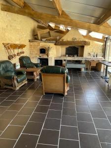 a large living room with leather furniture and a kitchen at L’alambic in Guizengeard