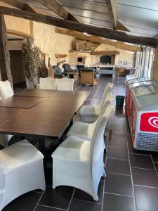 a dining room with a table and white chairs at L’alambic in Guizengeard
