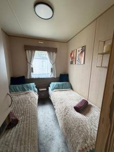 a small room with two beds and a window at Caravan Turnberry 2 , Seton Sands, Wifi in Port Seton +14 photos