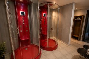 two red shower stalls in a bathroom at Diethnes Hotel in Athens