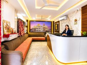 a woman standing at a bar in a hotel lobby at Hotel Mero Vrindavan in Chhatikara