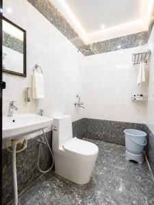 a bathroom with a white toilet and a sink at Hotel Mero Vrindavan in Chhatikara +21 photos