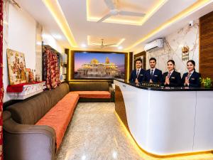a lobby of a hotel with three men standing at a bar at Hotel Mero Vrindavan in Chhatikara