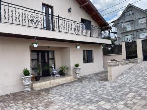 a white house with a balcony and potted plants at Casa Aylin in Corbu