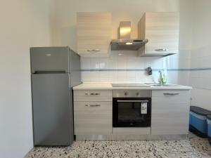 eine Küche mit Kühlschrank und Spüle in der Unterkunft Dilman appartamento in Poggiridenti