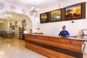 a woman standing at the reception desk of a safari hotel at Roswam Hotel in Keruguya +78 photos