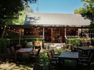 a restaurant with tables and chairs in front of a building at Vineyard Cottages - Kumeu in Waimauku