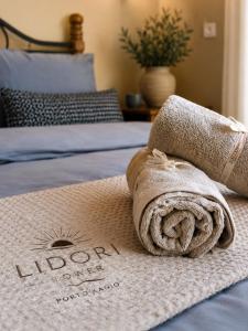 a towel sitting on top of a bed at Lidori Mani in Akhíllion