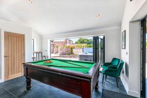 a room with a pool table and a green chair at Fairvale House in Northwich