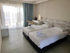 a bedroom with a large bed with towels on it at Evita Flamingo in Kos