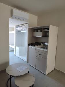 a kitchen with a white refrigerator and a table at Evita Flamingo in Kos
