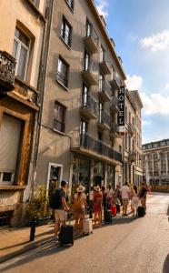 a group of people walking down a street with luggage at Brxxl 5 City Centre Hostel in Brussels