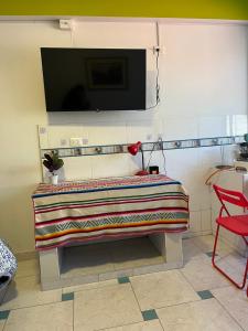 a room with a bench with a tv on the wall at Alojamiento en SICUANI in Sicuani +2 photos
