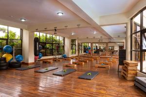 a gym with yoga mats in a room with windows at Roswam Hotel in Keruguya