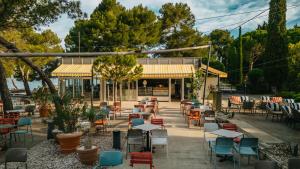 a group of tables and chairs in front of a restaurant at Holiday Park Vile - Terme Krka in Strunjan +105 photos