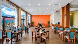 a restaurant with wooden tables and chairs and large windows at Mount Himalayan Hotel in Gangtok