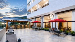 a patio with tables and chairs and red umbrellas at Mount Himalayan Hotel in Gangtok