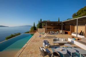 a villa with a swimming pool and a house at Villa Arkoudaki Luxurious Escape with Infinity Pool & Sea Access in Évyiros