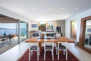 a kitchen and dining room with a table and chairs at Villa Arkoudaki Luxurious Escape with Infinity Pool & Sea Access in Évyiros