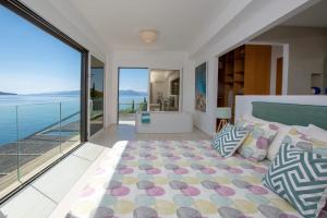 a bedroom with a large bed and a view of the ocean at Villa Arkoudaki Luxurious Escape with Infinity Pool & Sea Access in Évyiros